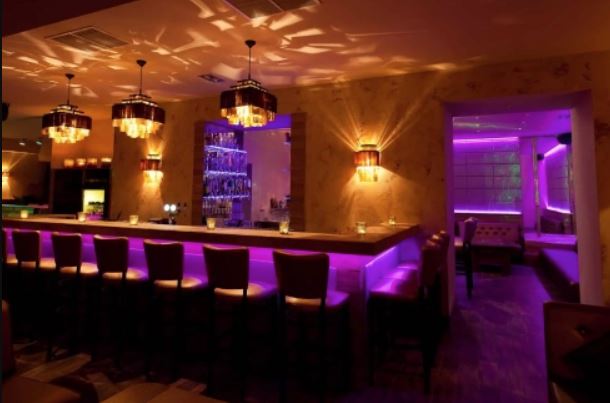 A bárpult lila színben, előtte bárszékekkel
